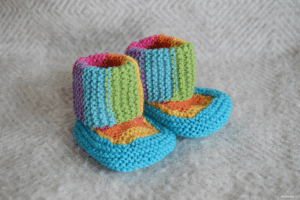 Läs mer om artikeln Stickade regnbågssockor/booties – Oh Baby! Baby Booties